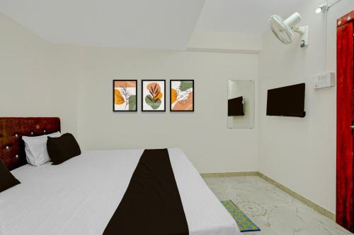 a bedroom with a bed with pictures on the wall at HOTEL O KB LODGING ROOMS in Itwāri