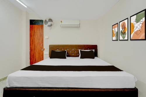 a bedroom with a large bed with black and white sheets at HOTEL O KB LODGING ROOMS in Itwāri