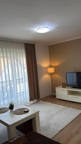 a living room with a television and a table at Mimi's Place in Gradačac