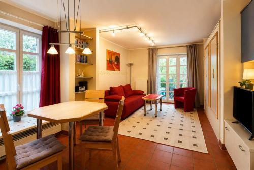 a living room with a red couch and a table at Strand-Appartement "Sanddornstübchen" in Dranske