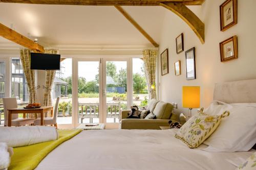 a bedroom with a large bed and a living room at 1 Bed in Piltdown oc-42814 in Newick