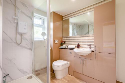 a bathroom with a toilet and a sink and a shower at 1 Bed in Piltdown oc-42814 in Newick