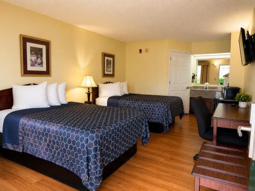 a hotel room with two beds and a desk at Jameson Inn - Perry in Perry
