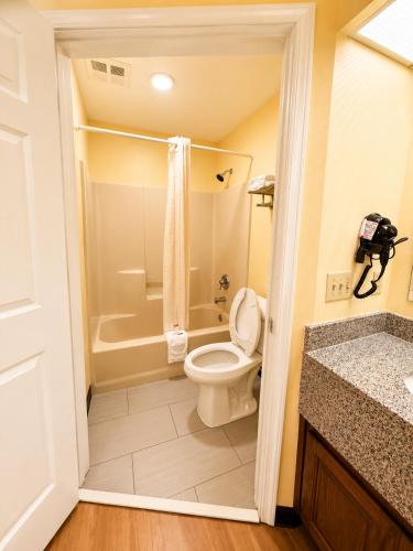 a bathroom with a toilet and a tub and a sink at Jameson Inn - Perry in Perry