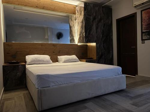 a bedroom with a large bed with a wooden headboard at Jinnah Mall Main Boulevard Jubilee Town in Lahore
