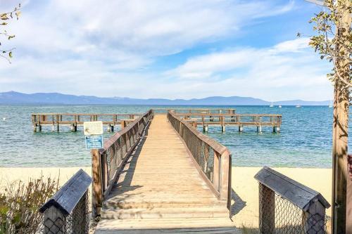 a wooden bridge over the water with two benches at Beautiful Condo with private beach access & shared pools in South Lake Tahoe
