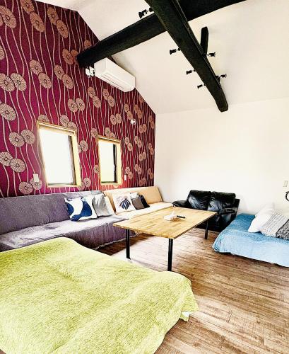 a living room with a couch and a table at とっくりhouse in Takashima