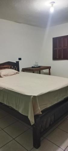 a large bed sitting in a room with a table at Pilatos in Ocosingo