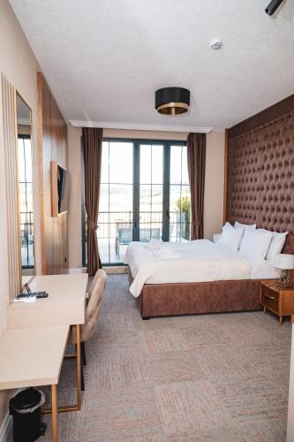 a hotel room with a large bed and a large window at Hotel Falcon in Žabljak