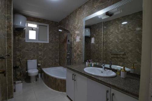 a bathroom with a sink and a tub and a toilet at Triple garden view hotel in Cairo