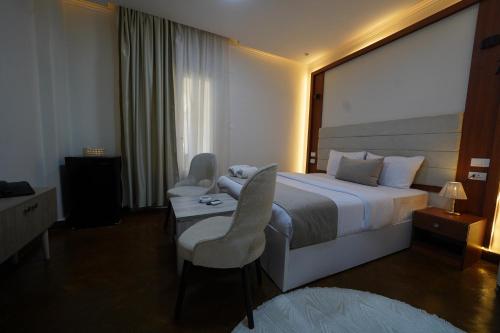 a hotel room with a bed and a table and chairs at Triple garden view hotel in Cairo