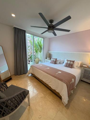 a bedroom with a large bed with a ceiling fan at Sol del Este Luxury by SH in San Andrés