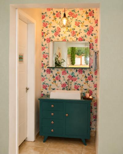 a bathroom with a green dresser and a mirror at Pousada Vó Santina in Protásio Alves