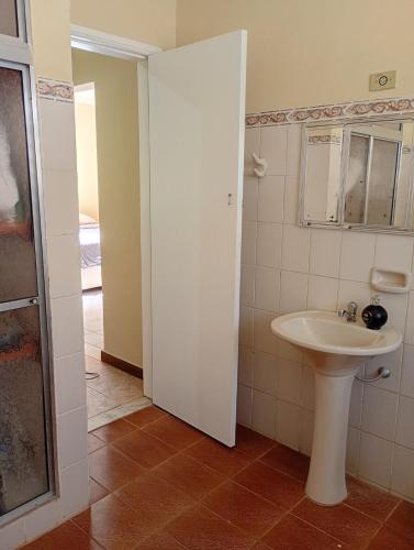 a white bathroom with a sink and a mirror at Loft no Centro, pertin de tudo! in Itanhandu