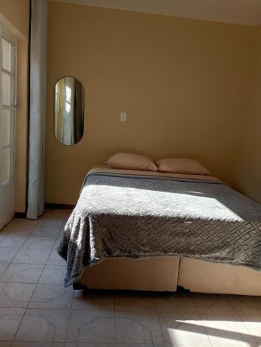 a bedroom with a large bed with a mirror at Loft no Centro, pertin de tudo! in Itanhandu