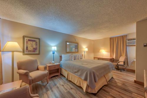 a hotel room with a bed and a chair at A Western Rose in Cody