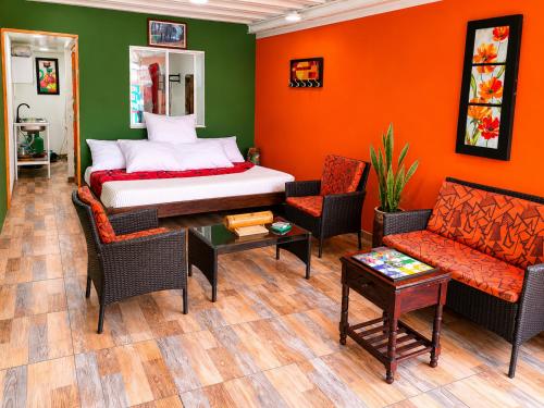 a bedroom with a bed and a couch and chairs at Central Apartment Salento Colombia in Salento