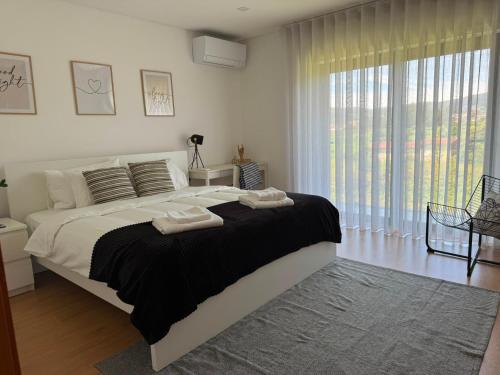 a bedroom with a large bed with two towels on it at Balutinha's house in Barcelos