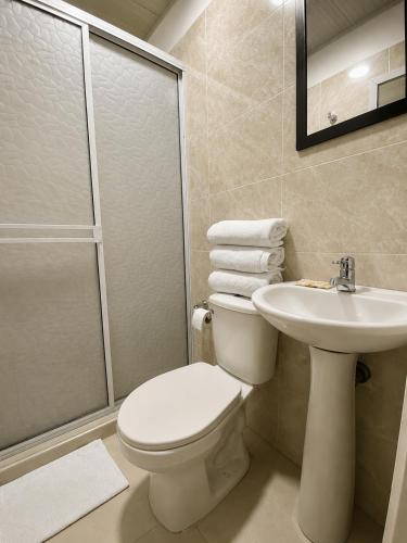 a bathroom with a toilet and a sink and a shower at HOTEL ELITE in Cali