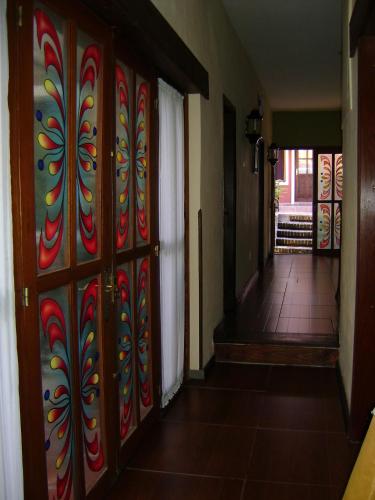 a hallway with a door with a colorful wall at Hotel Rivera in Colonia del Sacramento