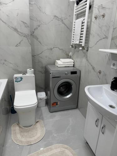 a bathroom with a washing machine and a sink at Modern & Quiet Apartment in Chişinău