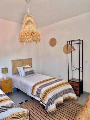 a bedroom with a bed and a chandelier at Casa das Portas de Évora in Estremoz