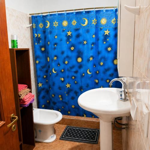 a bathroom with a blue shower curtain with stars and a sink at Depto rep del libano 11 capacidad 5 personas in La Banda