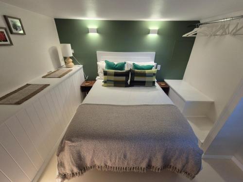 a large bed in a room with green walls at Green Scape - Whale Beach in Whale Beach