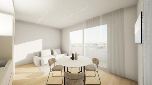 a white living room with a table and chairs at EMERALD Suites Cervia in Cervia