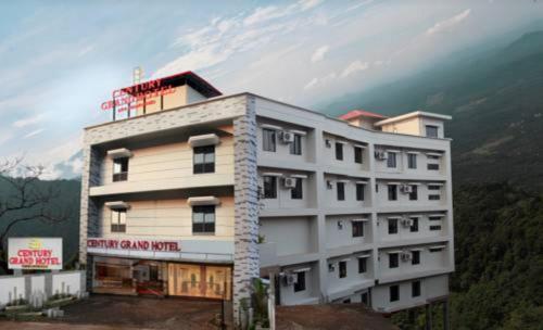 a large white building on top of a mountain at Century Grand Hotel in Mananthavady