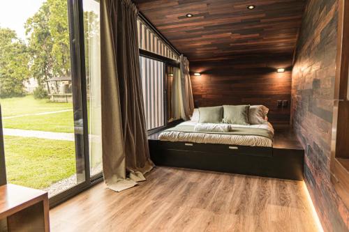 a bed in a room with a large window at Rosalia Haras Glamping - Experiencia ecuestre in Atlixco