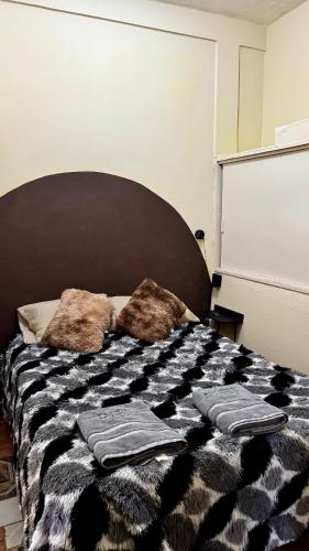 a bedroom with a bed with two pillows on it at Loft Industrial con fogatero in Mineral del Monte