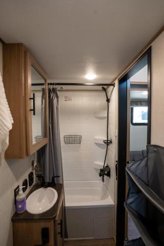 a small bathroom with a shower and a sink at Ouachita Outpost RV Park in Hodgen