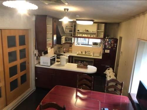 a small kitchen with a table and a counter top at Guesthouse Nara Backpackers in Nara