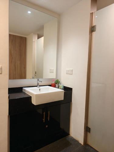 a bathroom with a white sink and a mirror at SF Roomstay Tunjong in Kota Bharu