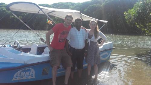 three people standing on a boat in the water at Araliya White House in Negombo