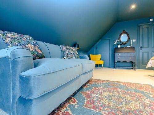 a blue couch in a blue room with a dresser at River Test View in Chilbolton
