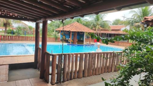 a swimming pool with a gazebo next to a building at Hotel E Pousada do Patrão in Bataguaçu