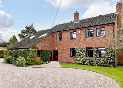 a brick house with a driveway in front of it at Field House in Baschurch