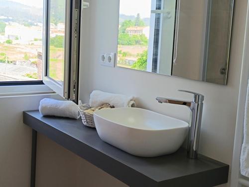 a bathroom with a white sink and a mirror at Aldea de Rosalía in Padrón