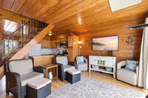 a living room with a staircase with chairs and a television at Chalet #16 in Stevensville
