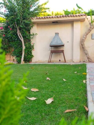 a yard with a bench and leaves on the grass at فيلا تسنيم للعائلات in Naj‘ al Aḩwāl
