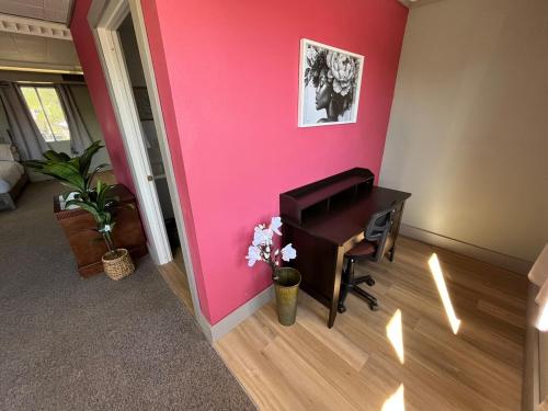 a room with a desk and a pink wall at House # 9 in Las Vegas