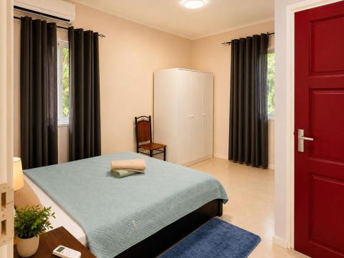 a bedroom with a bed and a red door at DOLFIJN STUDIOS Comfortable 1BR Apartment Fast WiFi AC North Paramaribo in Paramaribo