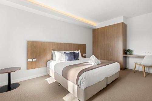 a bedroom with a large bed and a table at Modern 1 Bed Apartment - 6 Min Walk to Beach in Callala Beach
