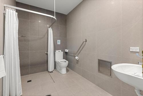 a bathroom with a toilet and a sink at Modern 1 Bed Apartment - 6 Min Walk to Beach in Callala Beach