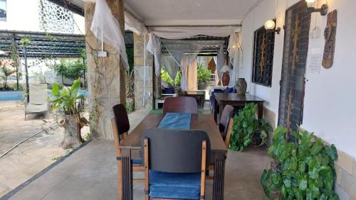 a restaurant with a long table and chairs and plants at Nyali Garden Escape Villa in Mombasa