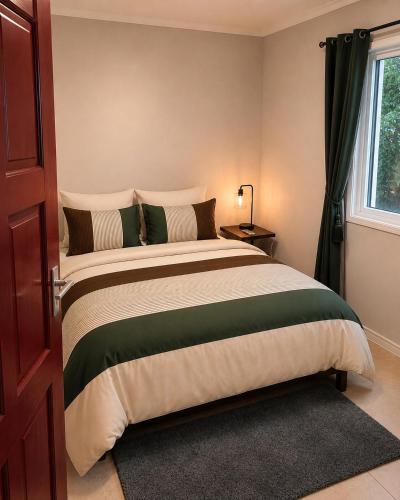 a bedroom with a large bed and a window at DOLFIJN STUDIOS Stylish 2BR Apartment Fast WiFi AC Near Center in Paramaribo