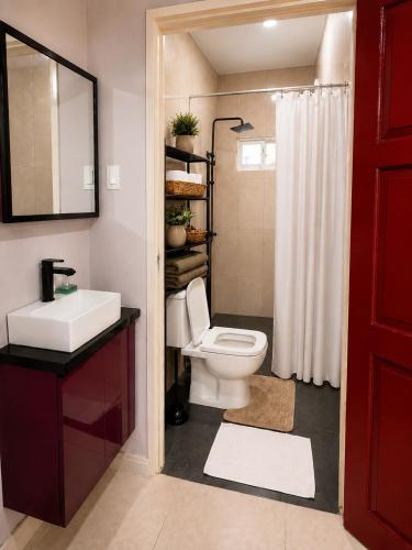 a bathroom with a toilet and a sink and a shower at DOLFIJN STUDIOS Stylish 2BR Apartment Fast WiFi AC Near Center in Paramaribo