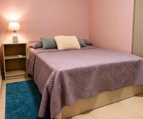 una camera da letto con un grande letto con una coperta viola di Spacious 1-BR Studio with Fast WIFI l Work-Friendly Stay a Paramaribo